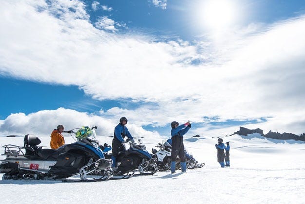 Grupo listo para comenzar el paseo en moto de nieve