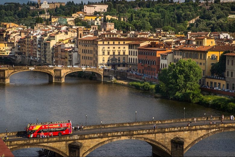 Autobús turístico atravesando un puente en Florencia