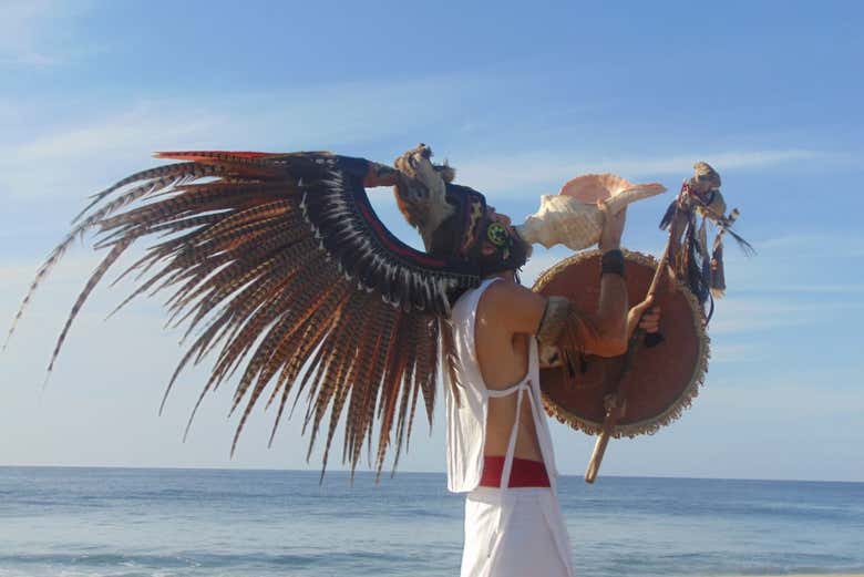 Un chamán haciendo sonar la caracola