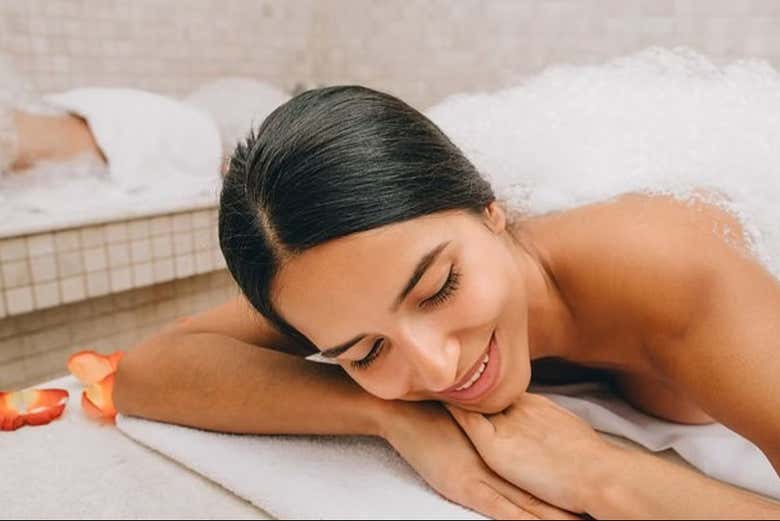 Una mujer disfrutando de un masaje con espuma